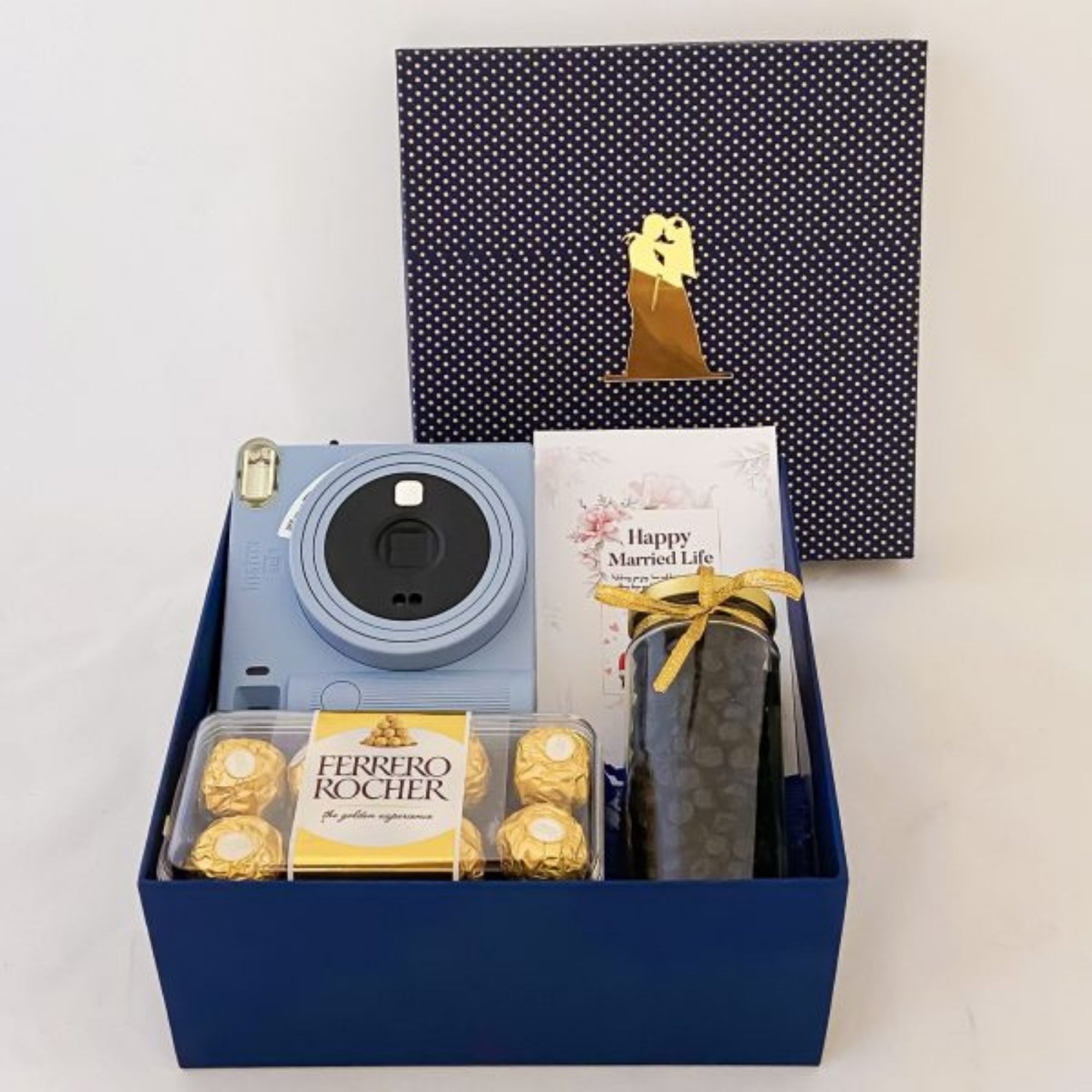Gift set with blue camera, Ferrero Rocher chocolates, and a card in a blue box.
