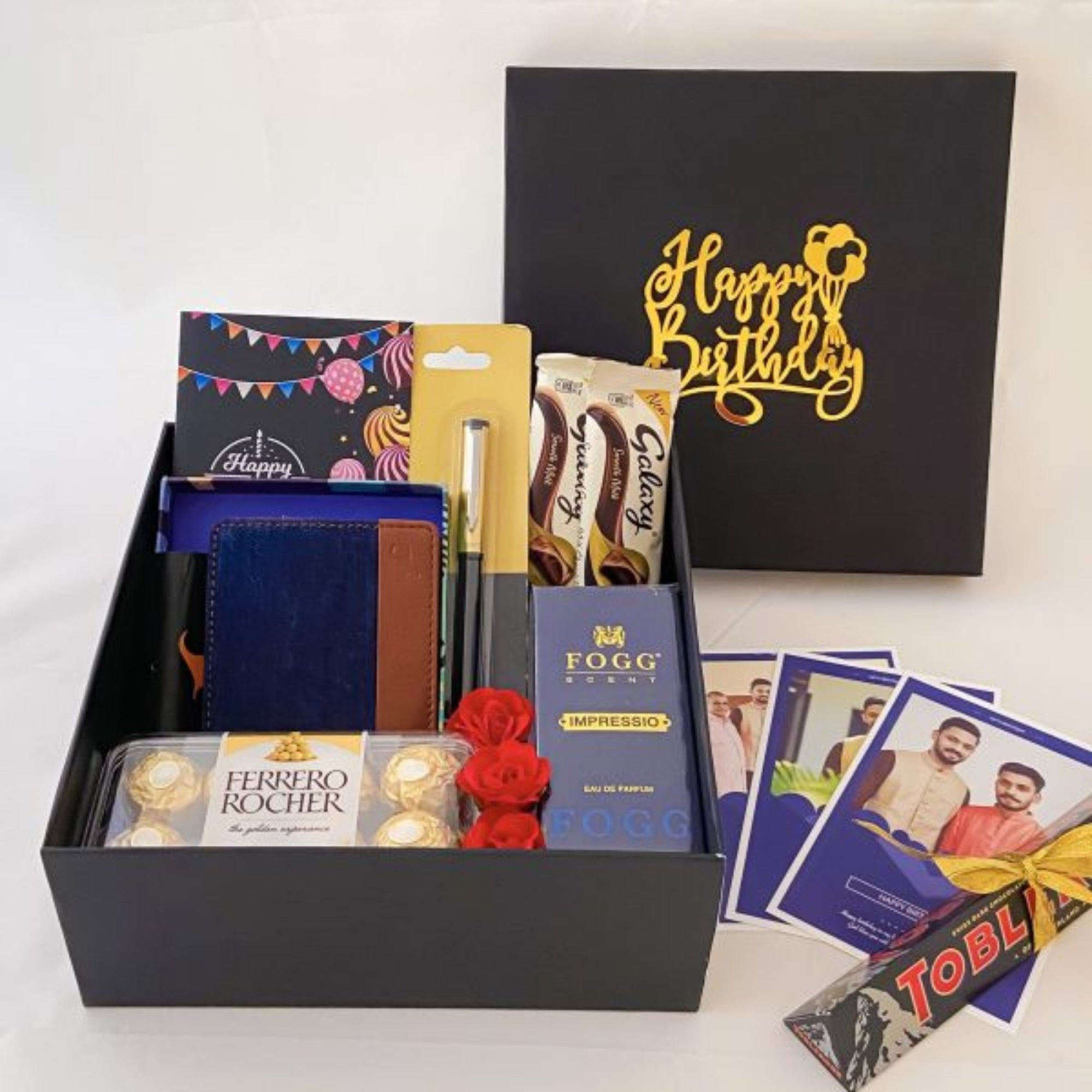 Gift box with stationery items, chocolates, and photos on a white background